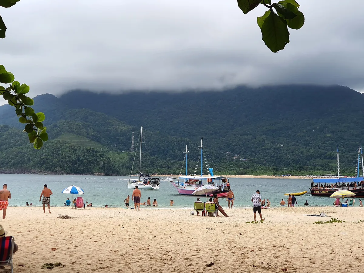 Praia no norte de Ubatuba com escunas e banhistas, programa para o feriado de Finados em Ubatuba