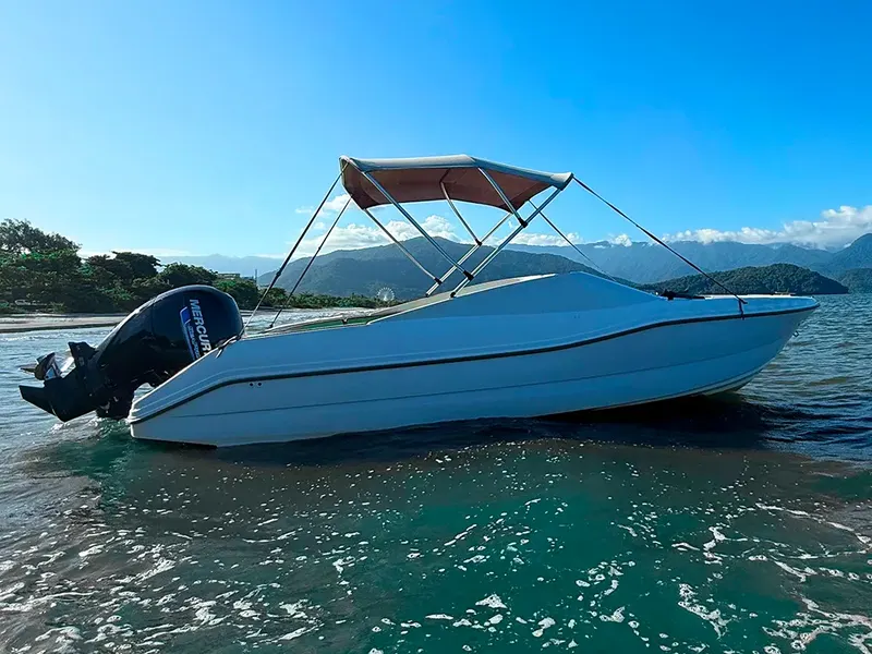 Lancha da Kaimares Turismo parada em praia de água transparente durante passeio de barco em Ubatuba
